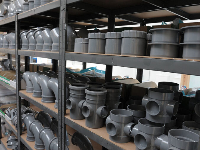 PVC elbows and connectors on a shelf in a plumning supply wholesaler