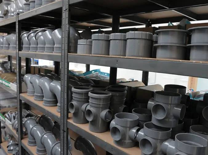 PVC elbows and connectors on a shelf in a plumning supply wholesaler