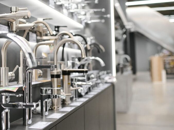 goose neck kitchen sink faucets in a plumning supply showroom